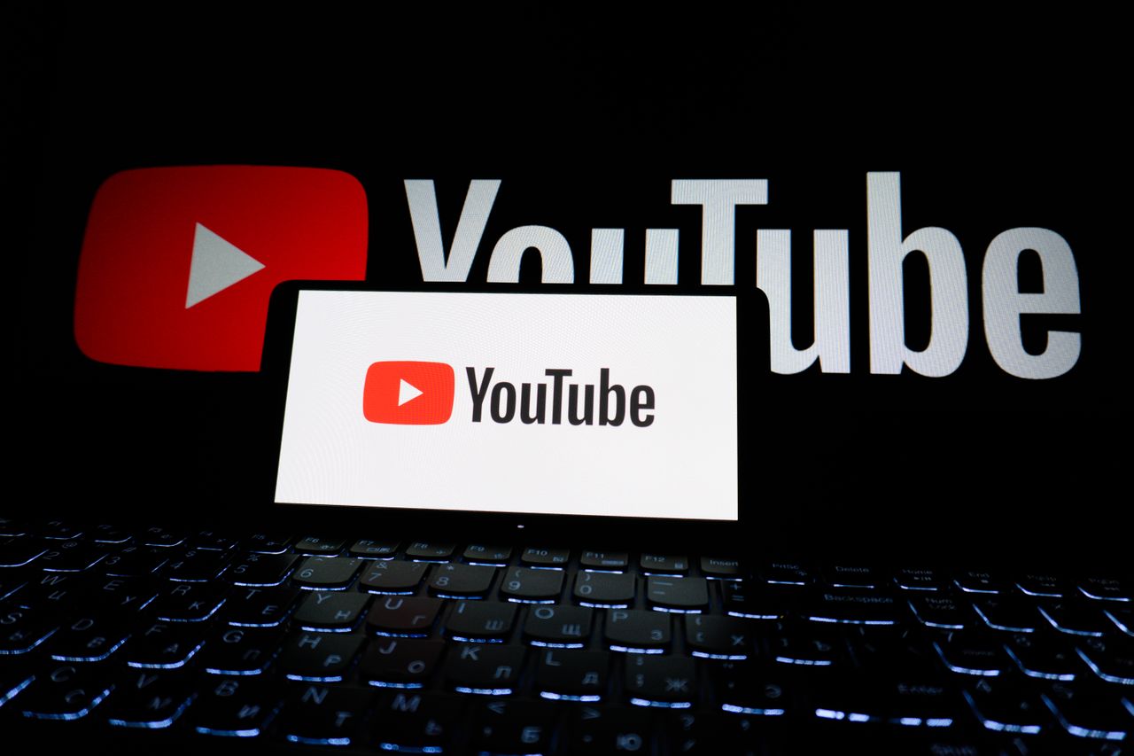 about-us-02 Close-up of YouTube logo displayed on a laptop screen in a dark environment.